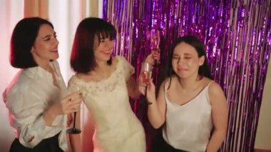 Neşeli bir gelin, güzel beyaz gelinliğini bekarlığa veda partisinde arkadaşlarına gösterir. Ellerinde bardaklarla, videodaki kızlar kadeh kaldırıyor.