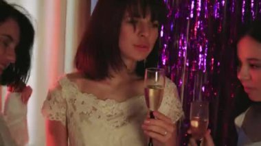 Neşeli bir gelin, güzel beyaz gelinliğini bekarlığa veda partisinde arkadaşlarına gösterir. Ellerinde bardaklarla, videodaki kızlar kadeh kaldırıyor.
