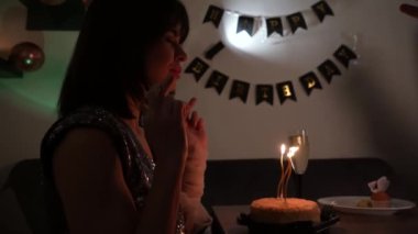 Kadın mumları üflerken doğum günü dileği diliyor, zarafet ve cazibeyle kutluyor. Genç bir kadın doğum gününde dilek tutar.