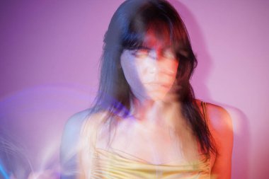 Sanat ve güzellik. Parlak gümüş bir yüzü ve vücudu dinamik bulanıklığı olan renkli bir kız modelin portresi. Parıltılı makyajla