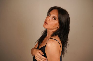 Kasıtlı olarak güzel, kendine güvenen bir kadın kameraya bakıyor, çekimlere katılıyor. Nitelikli kadın akıl hocası