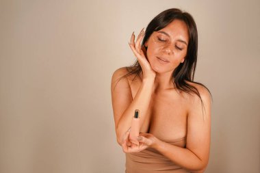 Yumuşak çilleri ve gevşek saçları var. Vakfın temelini elinde tutuyor. Cilt bakım ürünü