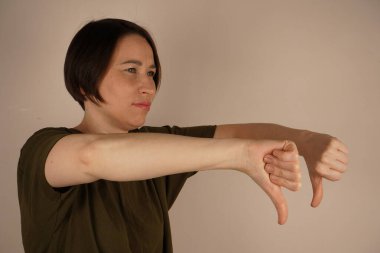 Kız sırtını eğdi, kollarını öne doğru uzattı ve hoşnutsuzluk gösteriyor. Suratı asıktı.