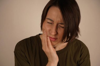 Duvarın yanında duran çok yorgun ve stresli genç bir iş kadını. Şoku atlatmak ve şiddetli bir acı hissetmek. Tatlı bir pastanın ardından