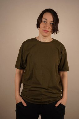 A girl in a green T-shirt and black jeans put her hand in her pocket clipart