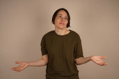 Şaşırmış, sevimli, güzel esmer ellerini iki yana açmış. Kapat.