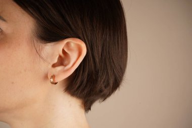 Mücevhersiz kadın kulağının yakın çekimi. Sağlık kontrolü, ziyaretçi doktorlar, kontrol. Kadın güzelliği, cilt bakımı, kozmetik ve kozmetik ürünleri, sağlık hizmetleri kavramı