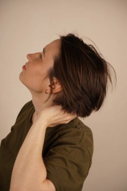 Çekici, bakımlı, neşeli bir kadının portresi yumuşak, parlak, ipeksi saçlara dokunarak bej arka planda izole edilmiş antistatik kaybını önlüyor.