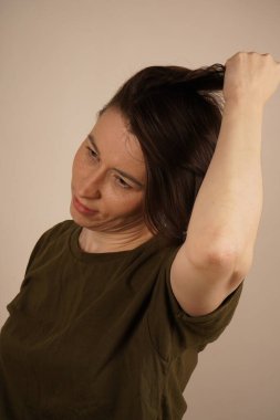 Tel takmış gülümseyen olgun bir kadının portresi. Bej arkaplanda izole edilmiş, portre