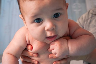 Çocuk gülümsüyor ve yataktaki kameraya bakıyor.