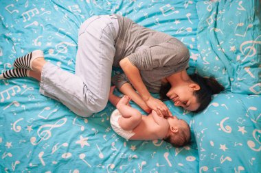 Güzel bir anne uyuyan bir bebeğin yanında yatar, onu okşar, sarılır. Çocuk güvenliği ve koruma, birlikte uyku.