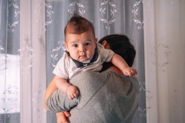 Close-up portrait of a happy mother holding a baby in her arms. Isolated on transparent background clipart