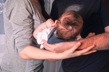 Anne ve baba yeni doğmuş bebeklerini tutarken gülümsüyor - yeni doğmuş bir bebekle mutlu genç ebeveynler