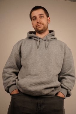 Siyah kot pantolon içinde, genç adam ellerini ön ceplerinde dinlendiriyor. Onun rahat duruşu kaygısız bir tavrı vurguluyor. İfade, sakin ve rahat görünmeni sağlar.