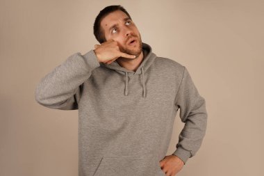 Adam elini kulağına yakın bir telefon gibi yerleştiriyor, arama yapıyormuş gibi yapıyor. Rahatlamış tavrı eğlenceli ve gayri resmi bir an olduğunu gösteriyor. Bu jest yaratıcılığı ve mizahı temsil eder.