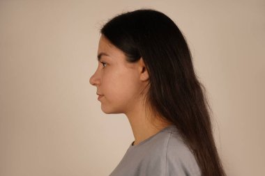 Rahat bir poz veren, doğal cazibe saçan bir kadının sakin yakın çekimi. Genç bir kadının yan görüntüsü. Avrupa görünümlü bir kadının güzel görüntüsü