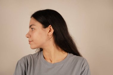 Rahat bir poz veren, doğal cazibe saçan bir kadının sakin yakın çekimi. Genç bir kadının yan görüntüsü. Avrupa görünümlü bir kadının güzel görüntüsü