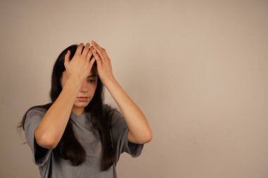 Kız ellerini başının üstüne koyuyor. Pişmanlık ifadesi ya da bir hatanın kabulü. Vücut dili bir farkındalık hissi veriyor. Bu an gerçek bir reaksiyonu yakalıyor.