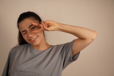 Barış işaretini oluşturan parmaklar uyum ve birliği temsil ediyor. Bu jest barış ve anlayış için evrensel bir semboldür, genellikle iyi niyet ve denge mesajı iletmek için kullanılır.