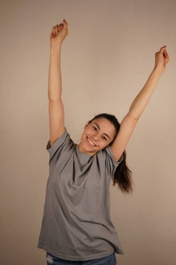 Yükseltilmiş kollar ferahlatıcı bir esneklik gösteriyor, rahatlama ve kolaylığı vurguluyor. Poz, doğal bir enerji ve konfor akışının altını çiziyor. Bu bir sakinleşme ve canlandırma anıdır.