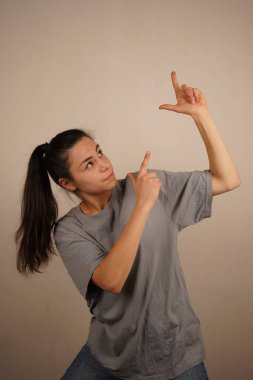 Bir kadın her iki işaret parmağıyla nişan alır gibi işaret eder. Bu jest niyet ve farkındalık yoluyla iyileşmeyi simgeliyor. Parmaklar bir yöne doğru hizalanmış gibi görünüyor.