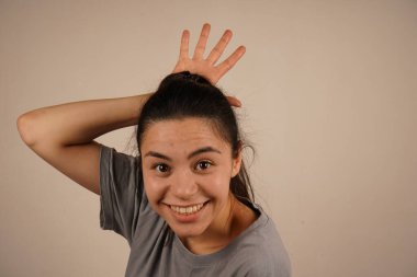 Bir el kafanın üstüne yerleştirilir ve taç şeklini alır. Bu jest eğlenceli bir dokunuş katıyor, asilzade izlenimini komik bir şekilde veriyor. Oyuncu taç güveni ve mizahı simgeler.