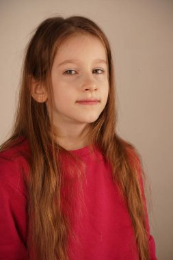 Portre parlak kızıl saçlı genç bir kızı gösteriyor. Yüzü saçları tarafından çerçevelenmiş, rahat ve sakin bir atmosfer yaratıyor. Nazik bir gülümsemeyle doğrudan kameraya bakar.