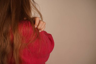 Küçük bir kız kolları omuzlarında kendine sarılıyor. Bu poz, masumiyet ve şefkat, sıcaklık, sevgi ve kişisel rahatlığı çağrıştırıyor. Huzurlu ve huzurlu görünüyor.