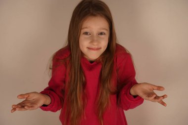 Küçük bir kız şaşkın bir bakışla kollarını açıp şaşkınlığını ifade ediyor. Masum ifadesi çocukluk duygularının saflığını vurguluyor. Filtresiz, büyüleyici bir merak anı.