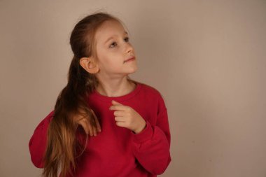 Kız parmaklarını dalgalı kızıl saçlarında gezdiriyor, canlı rengini vurguluyor. Kilitlerine hayran olduğu için yüzü gurur ve neşe saçıyor. Sahne güzelliği ve kendini beğenmişliği kutluyor.