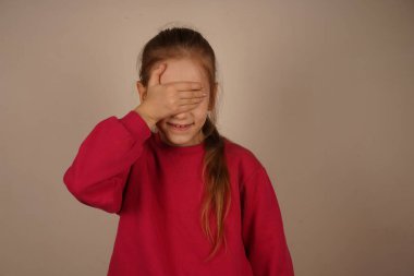 Kız neşeli bir jestle eliyle gözlerini kapatır. Onun parlak kızıl saçı onun parlak kişiliğini vurgular. Gençliğin eğlencesinin dokunaklı bir göstergesi