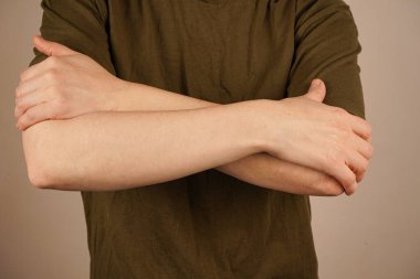 Sıkışmış eller, ışık ve tarafsız bir duvara karşı birleşmenin sembolik bir jestini oluşturuyor. Minimalist arka plan bağlantı mesajını güçlendirir. Sonsuz bir destek ve uyum sembolü.