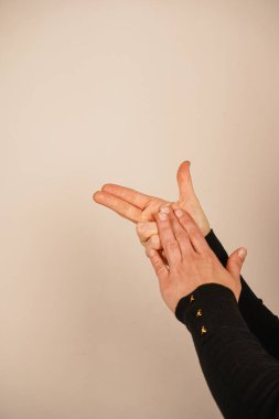 Parmaklar silah şeklini taklit etmek için düzenlenir, neşeli ve dinamik bir jest oluşturur. Bu sembolik el işareti güven ve enerji yayıyor. Gündelik ya da yaratıcı bağlamlarda yaygın olarak kullanılır.