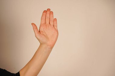 Nazikçe uzatılmış bir avuç içi, yardım ya da diyalog teklifini simgeler. Bağlantı ve destek temalarını somutlaştırır. Temiz zemin, jestlere odaklanmamızı sağlıyor. Merhaba demek için.