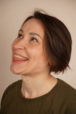 Düz dişleri olan, gülümseyen ve dil gösteren genç bir kadın. İzole bir arkaplanda