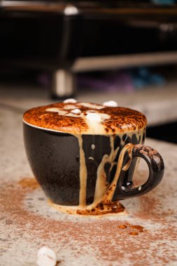 Overflowing cocoa with chocolate shavings sliding over the cup s edge creates a messy yet deliciously tempting display of indulgence