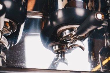 Steam rises as the caf coffee machine works its magic, its levers and nozzles captured up close, defining precision and quality