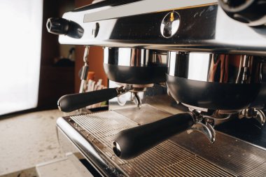The sleek coffee machine reflects the soft caf lighting, its levers and metallic body perfectly designed for precise and consistent brewing