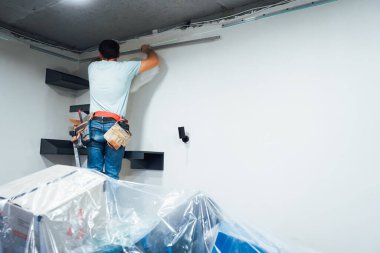 Koruyucu giysiler giyen adam, inşaatı dikkatlice hizalıyor, beceri ve profesyonellik gösteriyor.