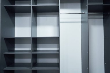 Open gray wardrobe with shelves and storage, minimalist design, standing in a modern, bright room