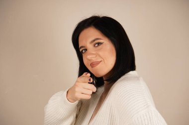 Genç kadın iki işaret parmağıyla tek bir yönü işaret ediyor. Bu da yolu gösteriyor. Duruşu özgüvenli ve anlamlı. Amaç ve berraklıkla dolu bir jest.