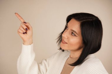 Duruşu özgüvenli ve anlamlı. Amaç ve berraklıkla dolu bir jest. Genç kadın iki işaret parmağıyla tek bir yönü işaret ediyor. Bu da bir yolu işaret ediyor.