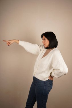 Genç kadın iki işaret parmağıyla tek bir yönü işaret ediyor. Bu da yolu gösteriyor. Duruşu özgüvenli ve anlamlı. Amaç ve berraklıkla dolu bir jest.