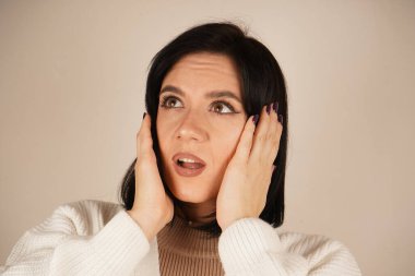 Elleri başının üstünde ve dirsekleri bükülmüş olarak poz vermesi bir rahatlama hissi veriyor. Duruş sükuneti ve sükuneti gösteriyor. Bu bir rahatlama ve rahatlama jesti.