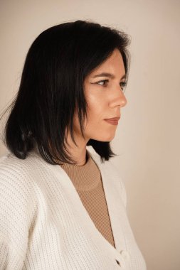 Kadının yüz hatlarını ve yüz ifadesini vurgulayan yakın plan bir fotoğraf. Hassas detaylara odaklanır, gözlerinden yüzünün ince hatlarına, duygularını ve kişiliğini aktarır.