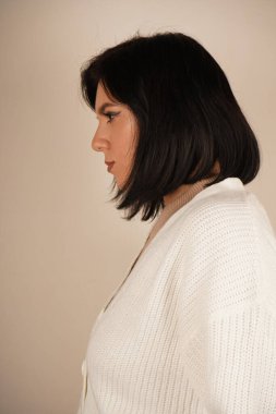 Genç bir kadının yan profili uzun saçlarını at kuyruğu şeklinde gösteriyor. Yüzünün zarif kıvrımı düzgün saç stilini tamamlıyor. Kompozisyon onun zarif basitliğini vurguluyor.