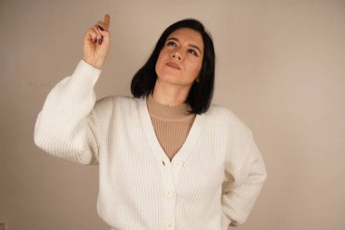 Yükseltilmiş işaret parmağı bir fikrin doğuşunu işaret eder, dikkat çeker. Bu jest yaratıcılığı, odaklanmayı ve bir ilham kıvılcımını yansıtıyor. Yenilik ve sezgilerle dolu dinamik bir an.