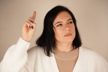 Yükseltilmiş işaret parmağı bir fikrin doğuşunu işaret eder, dikkat çeker. Bu jest yaratıcılığı, odaklanmayı ve bir ilham kıvılcımını yansıtıyor. Yenilik ve sezgilerle dolu dinamik bir an.