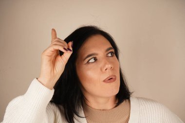 Yükseltilmiş işaret parmağı bir fikrin doğuşunu işaret eder, dikkat çeker. Bu jest yaratıcılığı, odaklanmayı ve bir ilham kıvılcımını yansıtıyor. Yenilik ve sezgilerle dolu dinamik bir an.