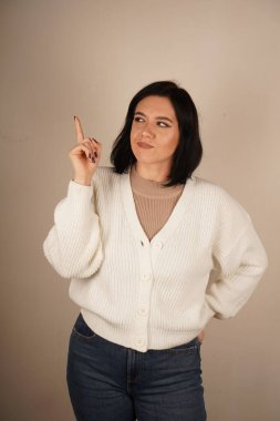 Yükseltilmiş işaret parmağı bir fikrin doğuşunu işaret eder, dikkat çeker. Bu jest yaratıcılığı, odaklanmayı ve bir ilham kıvılcımını yansıtıyor. Yenilik ve sezgilerle dolu dinamik bir an.